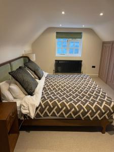 une chambre avec un grand lit et une fenêtre dans l'établissement Stunning Cotswolds Cottage 5 min from Soho Farmhouse, à Enstone