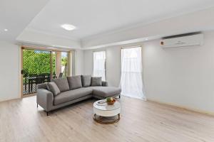 a living room with a couch and a table at Front Lake View 4Bed Home with Pool and Mins to Mall in Doolandella