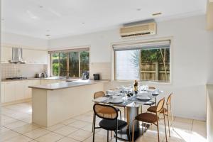 a kitchen and dining room with a table and chairs at Front Lake View 4Bed Home with Pool and Mins to Mall in Doolandella