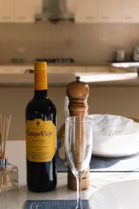 a bottle of wine and a glass on a table at Front Lake View 4Bed Home with Pool and Mins to Mall in Doolandella