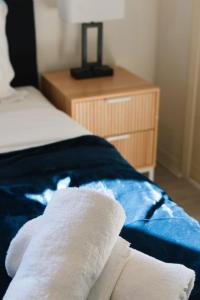 a bed with two white towels on top of it at Front Lake View 4Bed Home with Pool and Mins to Mall in Doolandella