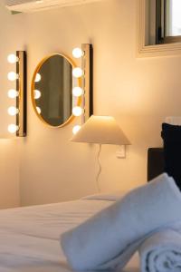a bedroom with a bed with a mirror and a lamp at Front Lake View 4Bed Home with Pool and Mins to Mall in Doolandella
