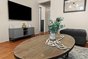 a living room with a table with a vase on it at Newly Renovated GEM Work Crews Welcome in Lincoln Park