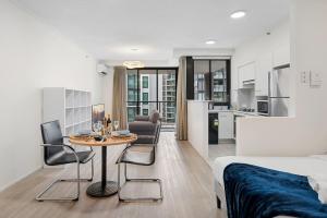 Un dormitorio con una cama y una mesa con sillas. en Best Value 2Beds Apt at CBD with Pool Gym Carpark, en Brisbane