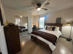 Un dormitorio con una cama y un ventilador de techo. en Home Sweet Stay, en Clovis