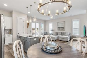 a kitchen and living room with a table and chairs at Seabreeze Sanctuary, Pool, 4 BDR , Golf Cart, Inlet Beach in Inlet Beach