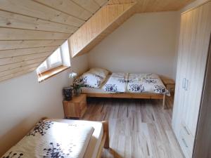 a small bedroom with a bed in a attic at Apartamenty Polańczyk in Polańczyk