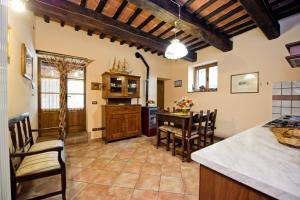 cocina y comedor con mesa y sillas en Agriturismo Podere Fucile, en Montepulciano
