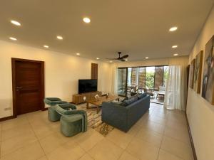 a large living room with couches and a tv at Joyau de pointe aux Canonniers in Grand Baie