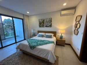 a bedroom with a large bed and a large window at Joyau de pointe aux Canonniers in Grand Baie +70 photos