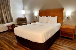 une chambre d'hôtel avec un lit et une chaise dans l'établissement Baymont by Wyndham Missoula, à Missoula