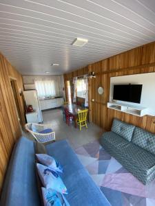 a living room with a couch and a tv at Casa Aluguel Porto Belo in Porto Belo