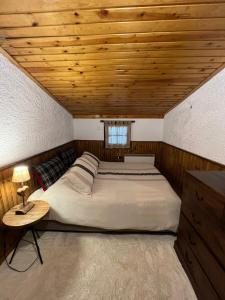 a bedroom with a large bed with a wooden ceiling at Petit Chalet in Eptalofos