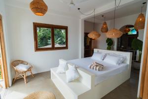 a bedroom with a white bed and a window at KOMOREBI Weligama in Weligama