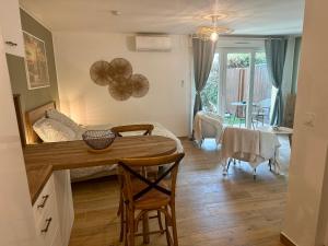 a kitchen and living room with a table and chairs at Le Greenhouse Studio Libourne in Libourne