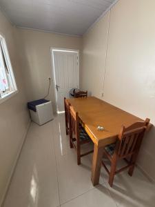a dining room with a wooden table and chairs at Casa Familiar da Mari in São Gabriel