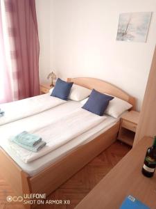 a bed with two blue pillows on top of it at Room in Lopar with Balcony, WIFI 4620-95 in Lopar