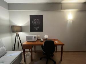 a room with a desk with a microwave and a bed at Hotel Live Lodge Vila Mariana Pq Ibirapuera UH402 in Sao Paulo