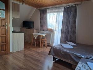ゾンプにある"U Krzysiaka" Apartament typu Studioのベッドとテーブルと窓のある寝室
