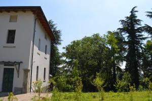 an old white house with trees in the background at Residence Podere San Marco Monolocali e Bilocali in Ghiaie