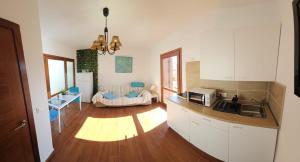 a kitchen with white cabinets and a living room at Land of Gavias in Tetir