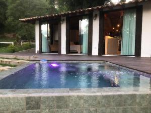 a swimming pool in front of a house at Pousada Vidinha Bela in Brazópolis