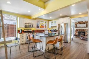 レドンドビーチにあるBeach Breeze Bungalow 1 Miles To Beach Cozyのバースツール付きの島のあるキッチン