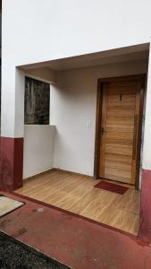 una stanza vuota con una porta e un pavimento in legno di Studio Marangoni Hospedaria Apartamento 2 a Treze Tílias