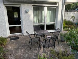 a patio with a table and chairs in front of a house at GartenOase in der Universitätsstadt 3 Zimmer Haus mit Parkplatz in Erlangen