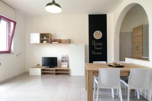 a dining room with a table and a tv at Casa Gardenia in Torre Vado