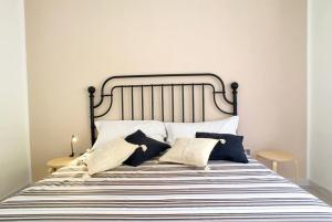 a bed with black and white sheets and pillows at Casa Gardenia in Torre Vado