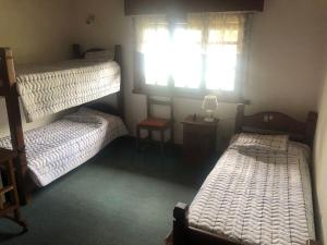 a room with three bunk beds and a window at Cabaña hasta para 6 personas en San Martin de los Andes in San Martín de los Andes