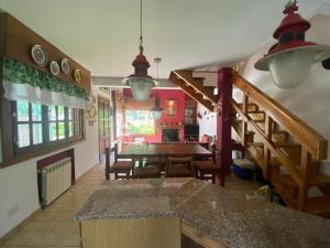 a kitchen and dining room with a table and a staircase at Cabaña hasta para 6 personas en San Martin de los Andes in San Martín de los Andes