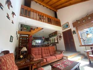 a living room with a couch and a staircase at Cabaña hasta para 6 personas en San Martin de los Andes in San Martín de los Andes