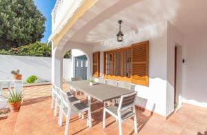 Un comedor con mesa y sillas en un patio. en Villa Can Che by Sonne Villas, en Cala Galdana