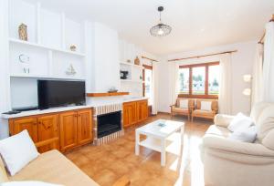 Una sala de estar con un sofá y un televisor. en Villa Can Che by Sonne Villas, en Cala Galdana