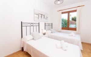 Dos camas en una habitación blanca con ventana. en Villa Can Che by Sonne Villas, en Cala Galdana 67 fotos más