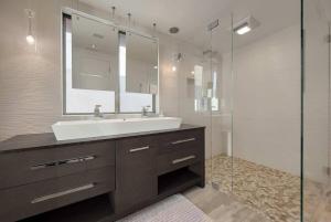 a bathroom with a sink and a glass shower at Hi-Tech Hideaway - Modern & Ocean Front! in Solana Beach +26 photos