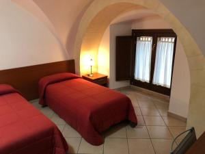 Una habitación de hotel con dos camas y una ventana. en B&B Tarasia, en Ragusa