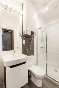 a bathroom with a toilet and a sink and a shower at Pokoje Cinema in Poznań
