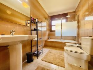 a bathroom with a sink and a toilet and a tub at Casa Hermanos by Costabravaway in Calonge