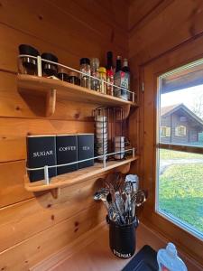 a kitchen with a wooden wall with shelves and a window at Blockhaus Holzzeit im Bayerischen Wald in Stamsried