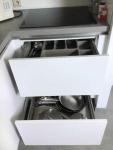 an open drawer in a kitchen with pots and pans at Cosy attic apartment, terrace, 1 bedroom south in Opdorp