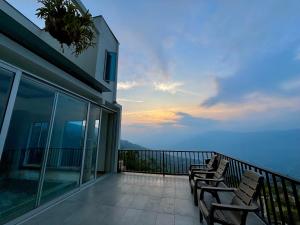 a balcony with chairs and a view of the ocean at Villa Entre Nubes in El Hatillo
