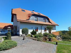 a white house with an orange roof at Ferienwohnungen Haus Marianne in Langscheid