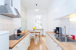 a kitchen with white cabinets and a wooden counter top at Apartment Winsstr. 68 in Berlin