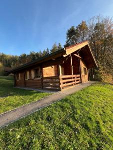 a log cabin in a field with a grass field at Blockhaus Holzzeit im Bayerischen Wald in Stamsried