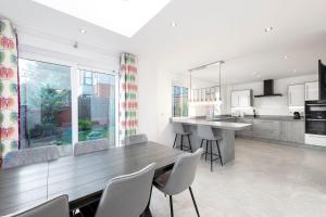 a kitchen with a wooden table and chairs at Beachwood Retreat in Sheringham