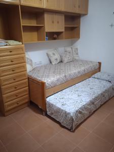 a bedroom with two beds and a dresser and cabinets at Apartamento entre playa y montaña in Sanet y Negrals