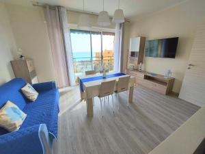 ピエトラ・リーグレにあるLa casa di Giuly, vista mare, parcheggio privatoのテーブルと青いソファのあるリビングルーム